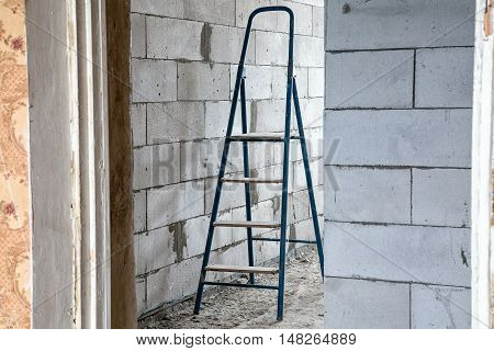 Stepladder in the dirty room during capital repair