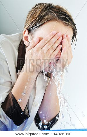 bautiful young woman wash face with clean water isolated on white in studio