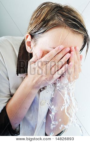 bautiful young woman wash face with clean water isolated on white in studio