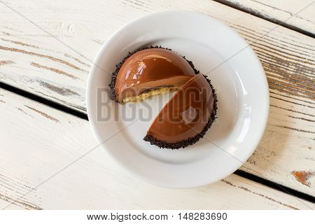 Plate with sliced dessert. Top view of dome cake. Glaze and sweet mousse. Custom made confectionery with icing.