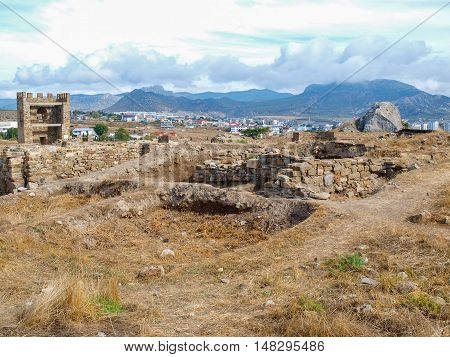 Ancient walls and guard towers on a background of modern buildings in the city of Sudak Crimea
