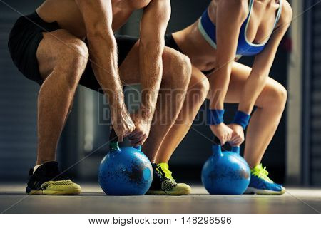 Fit man and woman training by kettle bell.
