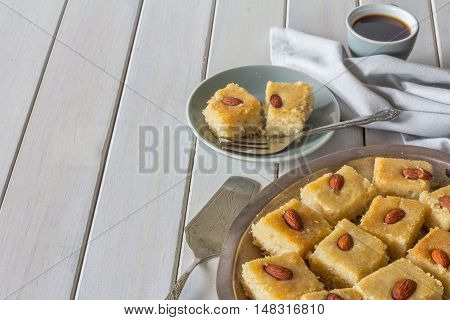 Homemade Basbousa with Coffee on White Wooden Table Horizontal with Copy Space