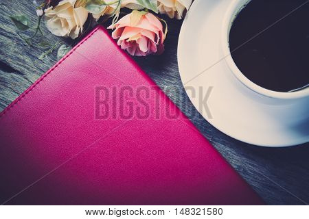 notebook flower and cup of coffee on the desk