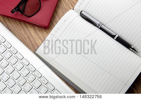 Book With Pen And Keyborad On Desk