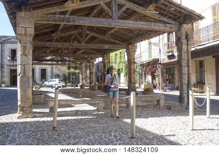 Photographer Walking Under A Porch In Lagrasse, France