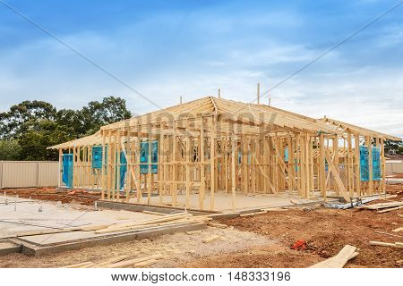 New residential construction home framing against a blue sky. Construction site preparation