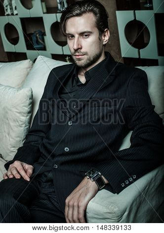 Businessman sitting on an armchair. Fahion man.