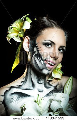 Young attractive girl with creative make-up for Halloween. Mysterious and frightening image of lilies. Witchcraft. Jitters.