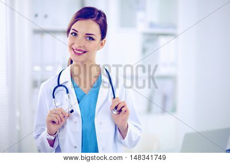 Portrait of happy successful young female doctor holding a stet