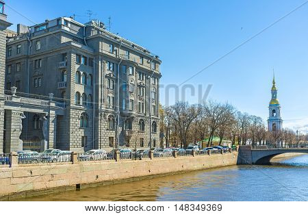The grey building of Lendoc Art Center with the tall bell tower of the Sailors' Cathedral on the background St Petersburg Russia.