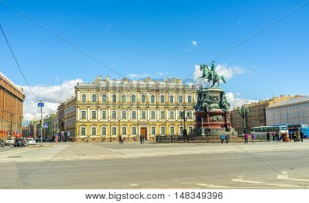 SAINT PETERSBURG RUSSIA - APRIL 25 2015: The monument of Tsar Nicholas I located in St Isaac's Square with the neoclassical building of Vavilov Institute of Plant Industry on the background on April 25 in Saint Petersburg.
