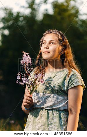 Portrait of a beautiful young teenage girl with a branch of willow in his hands