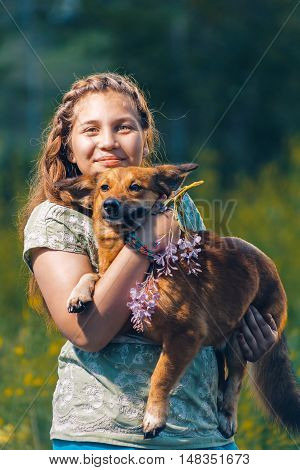 Portrait of a beautiful young teenage girl with a dog on his hands