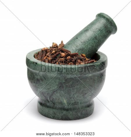 Organic black clove (Syzygium aromaticum) on marble pestle. Isolated on white background.