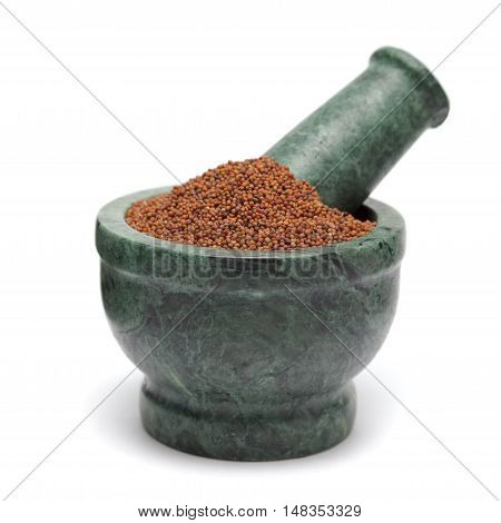 Organic Small Brown Mustard Seeds (Brassica juncea) on marble pestle. Isolated on white background.