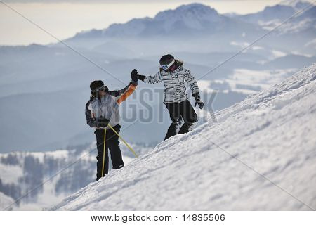 Счастливая пара вождения и отдыха с сноуборд и лыжных на зимнего сезона на горе