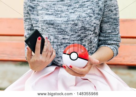 Irkutsk, Russia - September 15, 2016: Issue 2016 Image: Fan Art and Pokebol Pikachu Pokemon smartphone in the hands of women. Play Pokeball - this equipment to catch Pok mon in the game Pok mon go