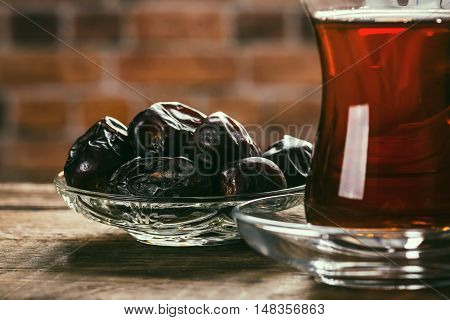Tea with dates on wooden table. Selective focus