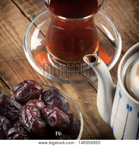 Tea with dates on wooden table. Selective focus