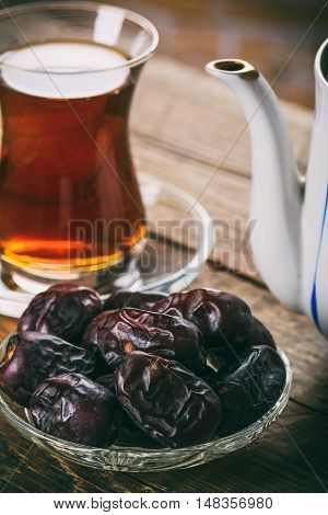 Tea with dates on wooden table. Selective focus