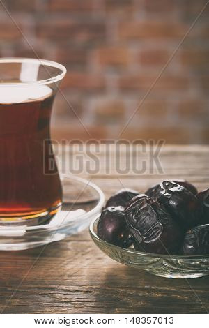 Tea with dates on wooden table. Selective focus