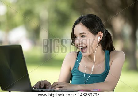 Joyful casual asian woman working with her notebook