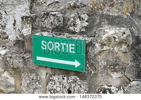 Saint Martin de Boscherville France - june 22 2016 : an exit sign on a stone wall