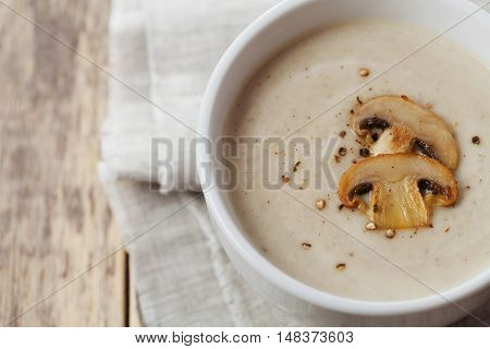 Cream soup with mushrooms champignon and potato in white bowl, vintage style.