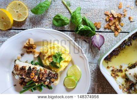 Zander fish fillet dish on a plate on white wooden table