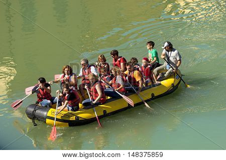 VERONA ITALY - SEPTEMBER 17 2016: Tocati International festival of street games. Rafting a group of people with an instructor on an inflatable boat in the city of Verona on the Adige river near Ponte Pietra