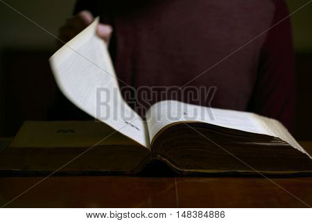 Man Flipping through the Pages of an old book