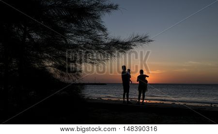 Silhouette Father and mother holding son's during sunset at the beach Kg.Pohon Batu LABUAN F.T , MALAYSIA, January 2016