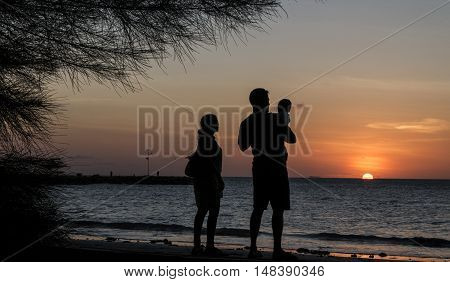 Silhouette Father and mother holding son's during sunset at the beach Kg.Pohon Batu LABUAN F.T , MALAYSIA, January 2016