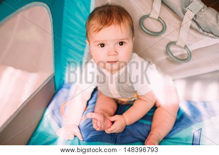 Cute Little Baby Boy Playing In Colorful Playpen, Indoors. Beautiful Child Having Fun At Nursery.
