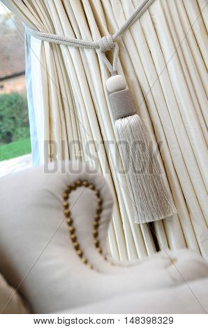 a cream coloured curtain tassle and curtain