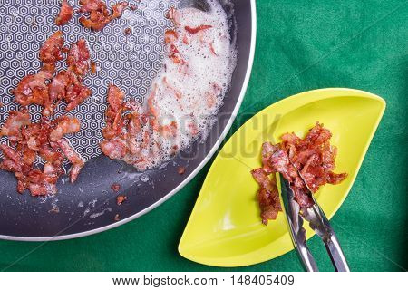 Chef poring fried bacon from pan with tongs / cooking Beaked spinach concept