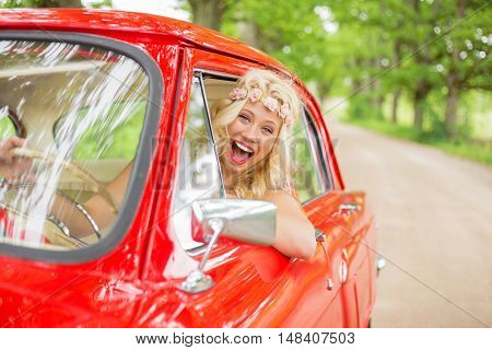 Happy woman enjoying driving a retro car