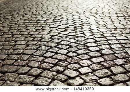 Perfect cobblestone streets of the city. Paving stone roadbed made with small stone blocks.
