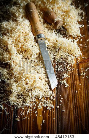 Woodworking tools. Chisel with sawdust on a wooden table