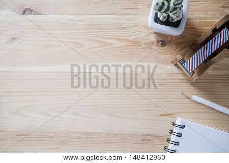 Topview of office stuff on wooden working table. Mock up. Sticky tape note paper white blank notebook post-it note pencil.