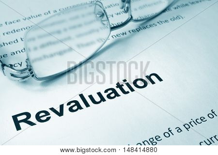 Paper with sign Revaluation and a pen. Business concept.