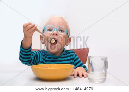 Baby boy eating furcula of yellow dish yourself