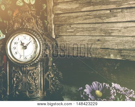 still life of antique clock on woolden wall background using vintage tone Retro filter effect Soft focus Low light. (selective focus)