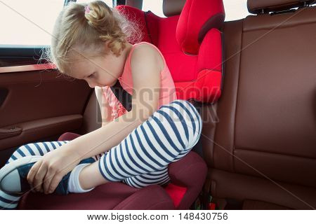 Portrait Of Happy Little Child Girl Sitting Comfortable In Car Seat With Safety Belts Enjoying Ride