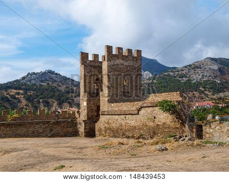 Fortress wall and majestic stone gates of the fortress against the backdrop of mountain scenery in Sudak in Crimea