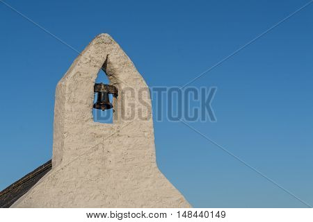 Small bell tower with a bell of a Welsh country chapel, against a deep blue sky