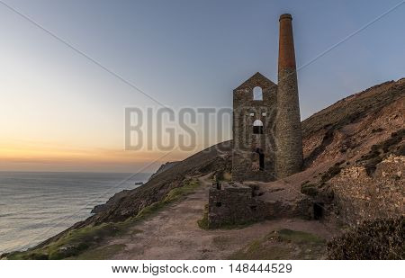Derelict Cornish tin mine, on the cliff edge, at sunset
