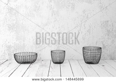 Vintage wire baskets on white wooden rustic floor industrial wicker storage bins