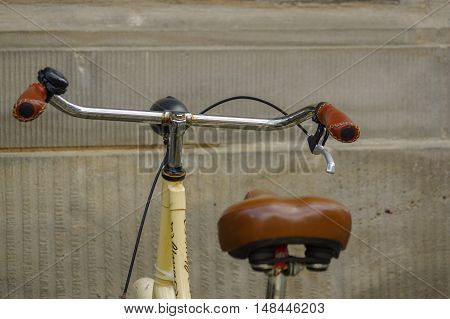 detail of old yellow bicycle. leather seat with shock absorbers and wheel